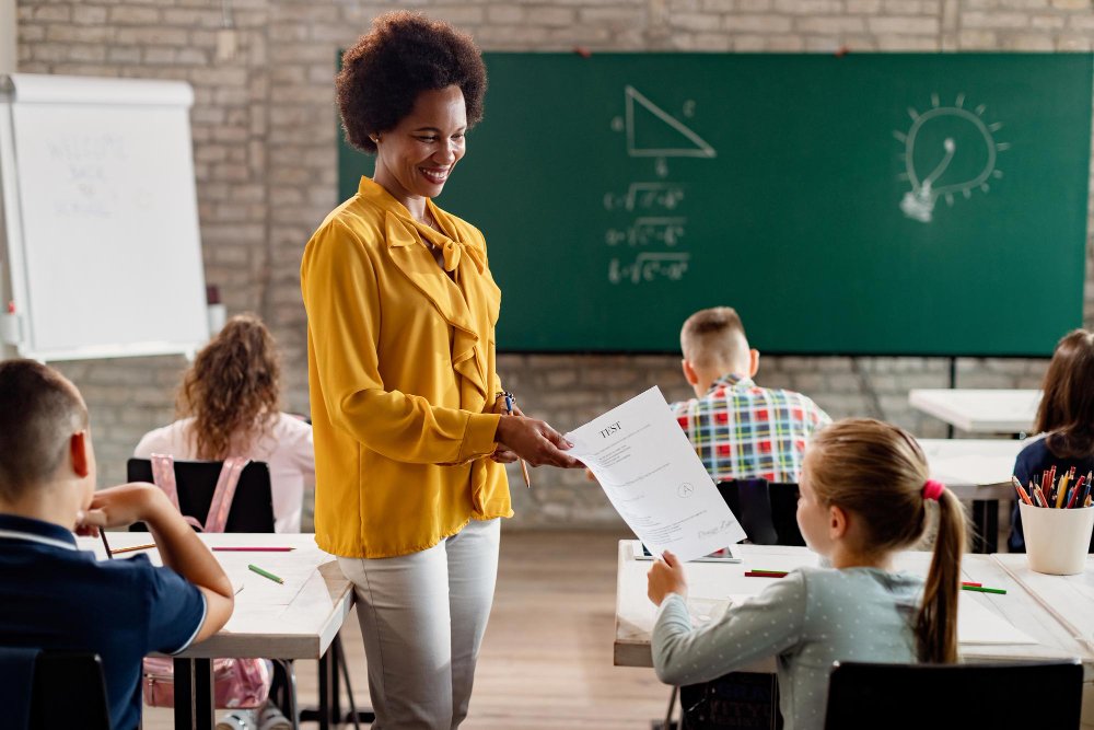 mulher entregando resultado de um teste para uma criança em sala de aula